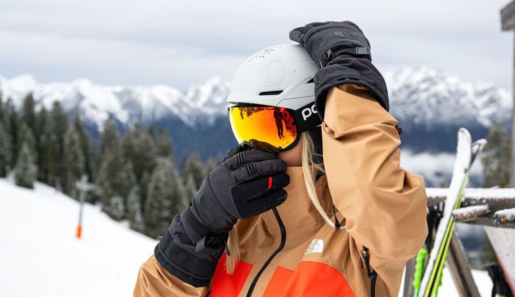 Skifahrerin justiert ihre Skibrille Skifahrerin justiert ihre Skibrille