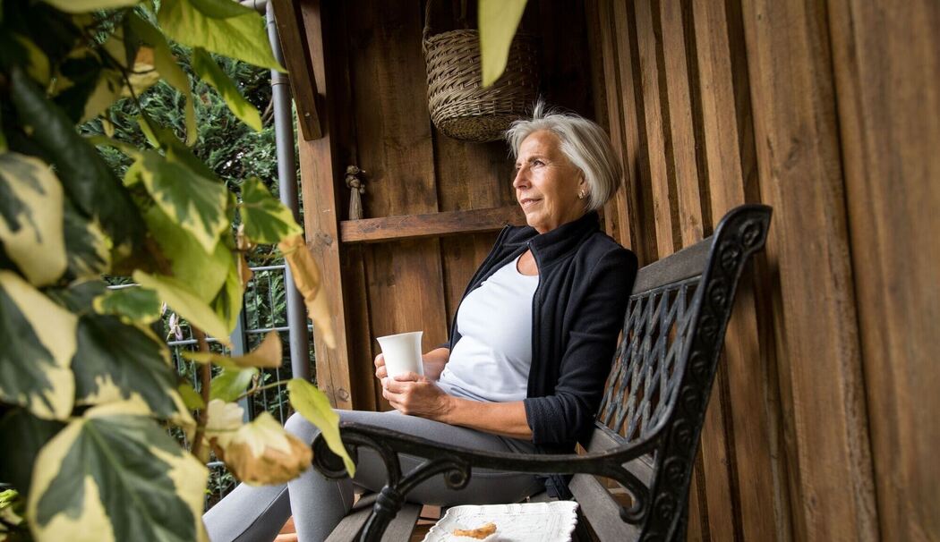 Eine ältere Dame sitzt in einem Garten Eine ältere Dame sitzt in einem Garten