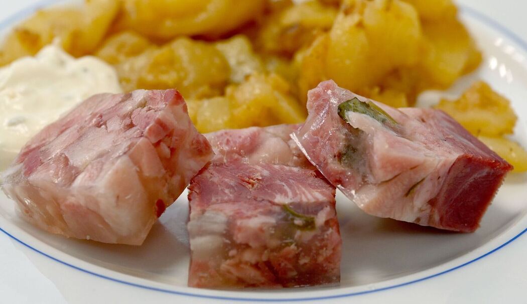 Sülze liegt auf einem Teller mit Bratkartoffeln Sülze liegt auf einem Teller mit Bratkartoffeln