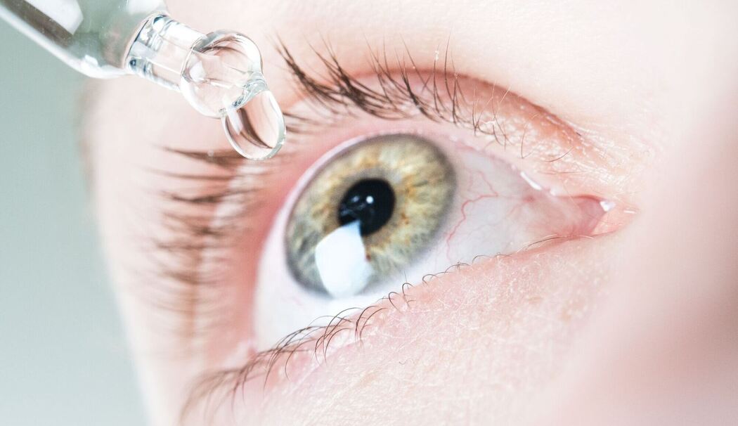 Frau benutzt befeuchtende Augentropfen Frau benutzt befeuchtende Augentropfen