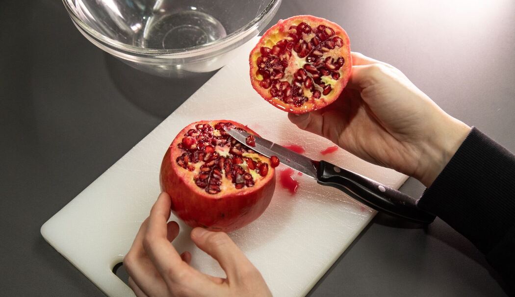 Granatapfel wird aufgeschnitten Granatapfel wird aufgeschnitten