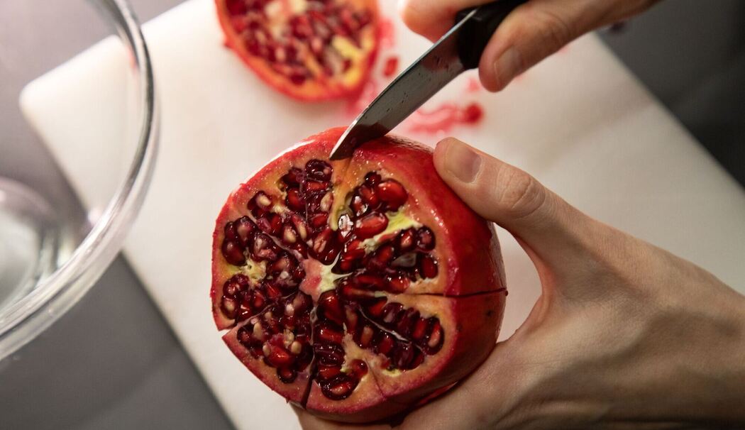 Granatapfel wird entlang der Kammern eingeschnitten Granatapfel wird entlang der Kammern eingeschnitten