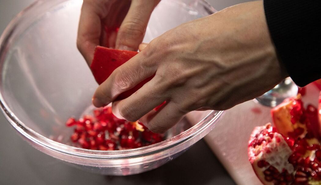 Kerne eines Granatapfels werden aus der Frucht gelöst Kerne eines Granatapfels werden aus der Frucht gelöst