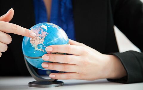 Eine Frau schaut auf einen kleinen Globus im Büro