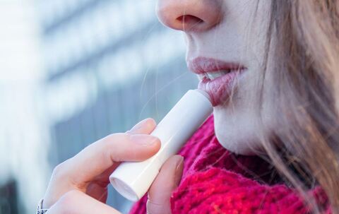 Frau trägt eine Lippenpflege auf