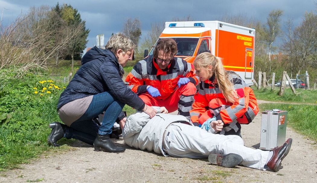 Rettungsdienst untersucht bewustlosen Mann Rettungsdienst untersucht bewustlosen Mann