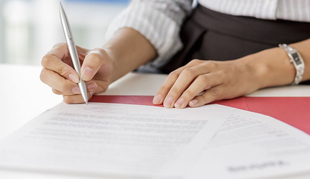 Frau unterschreibt ein Arbeitszeugnis