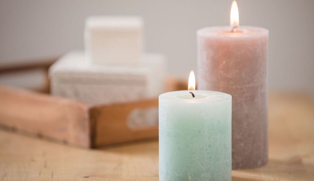 Blockkerzen brennen auf einer Kommode Blockkerzen brennen auf einer Kommode