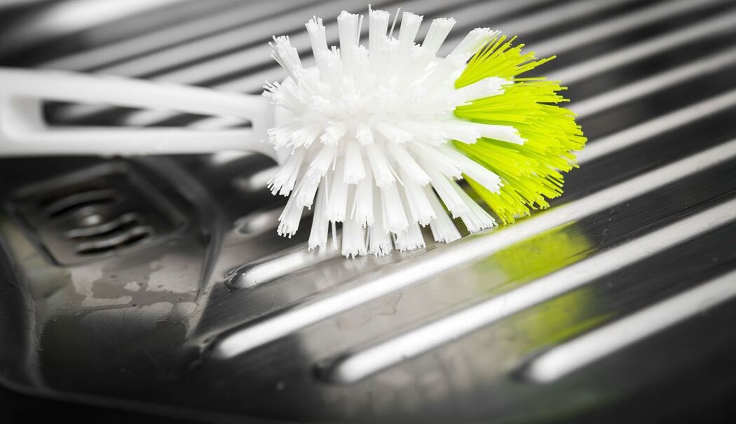 Eine Spülbürste liegt auf der Abtropffläche einer Spüle