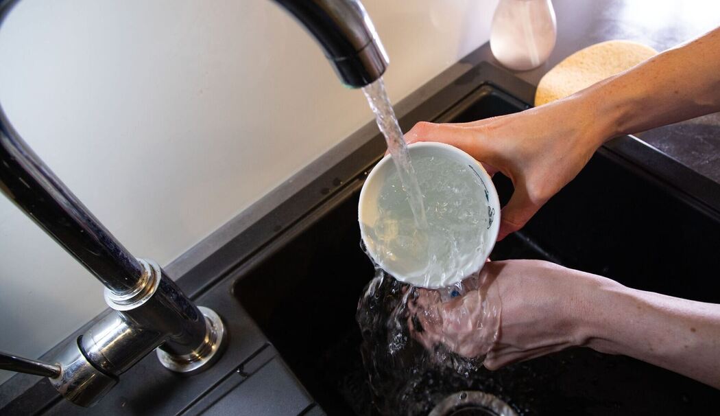 Tasse wird mit klarem Wasser ausgespült Tasse wird mit klarem Wasser ausgespült
