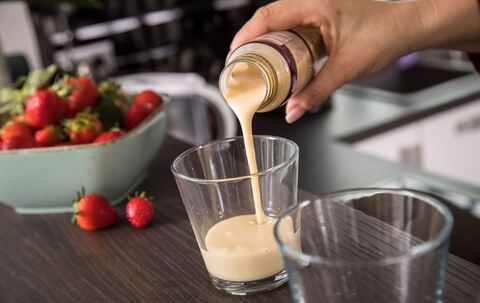 Eine Frau gießt ein Fertig-Getränk in ein Glas