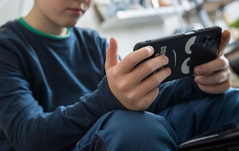 Junge schaut auf sein Smartphone