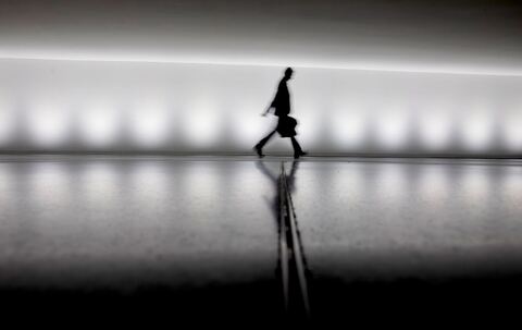 Eine Person geht an einem Gebäude vorbei