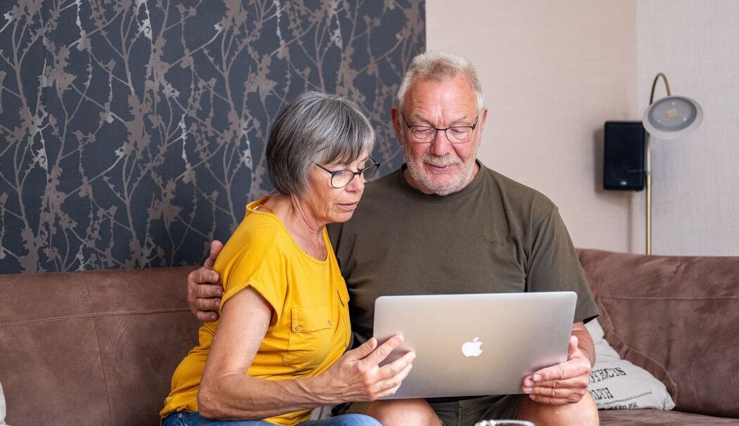 Ein Paar schaut auf einen Laptop Ein Paar schaut auf einen Laptop