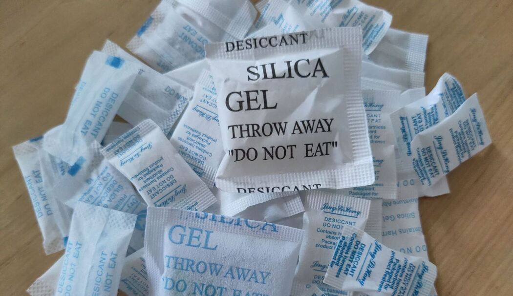 Tütchen mit Silica-Gel liegen auf einem Tisch Tütchen mit Silica-Gel liegen auf einem Tisch