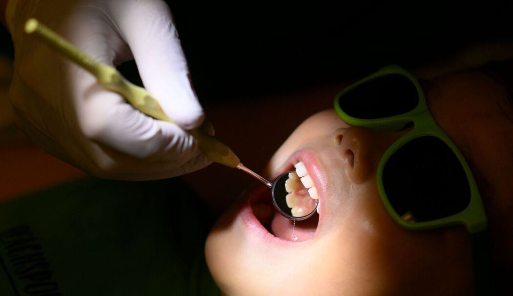 Eine Kinderzahnärztin untersucht ein dreijähriges Kind Eine Kinderzahnärztin untersucht ein dreijähriges Kind