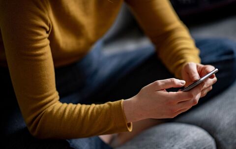 Eine Frau hält ein Smartphone in den Händen