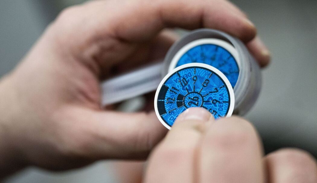 Prüfplakette in Blau bei einer Hauptuntersuchung Prüfplakette in Blau bei einer Hauptuntersuchung