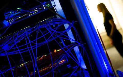 Ein Serverschrank mit blinkenden Lampen und Kabeln