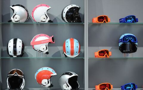 Skihelme liegen bei Sportartikelmesse ispo in einem Regal