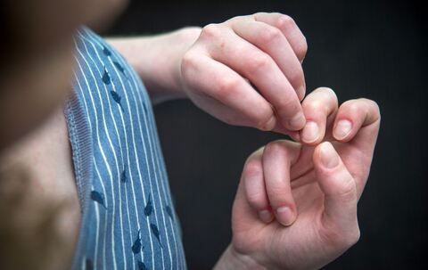 Eine Frau knibbelt an ihren Fingernägeln