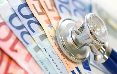 Ein Stethoskop liegt auf Geldscheinen