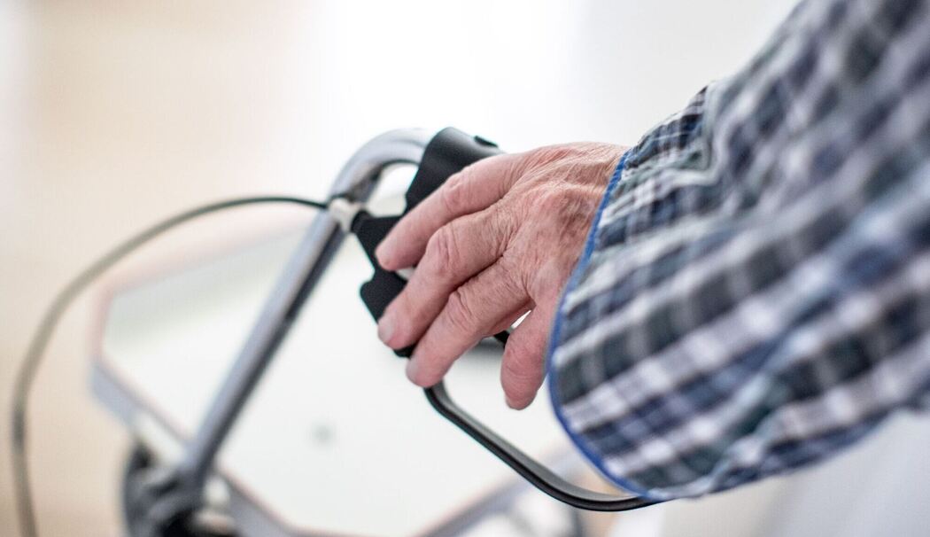 Mann stützt sich auf seinen Rollator Mann stützt sich auf seinen Rollator