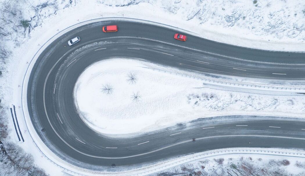 Autos fahren bei winterlichem Wetter eine Serpentine entlang