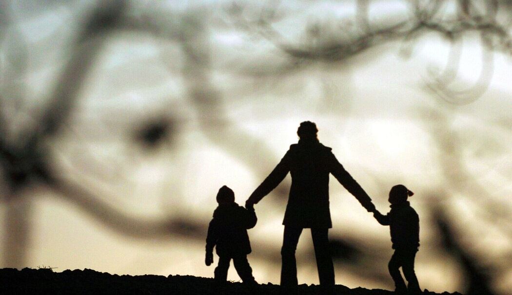 Eine Frau geht mit ihren Kindern spazieren Eine Frau geht mit ihren Kindern spazieren