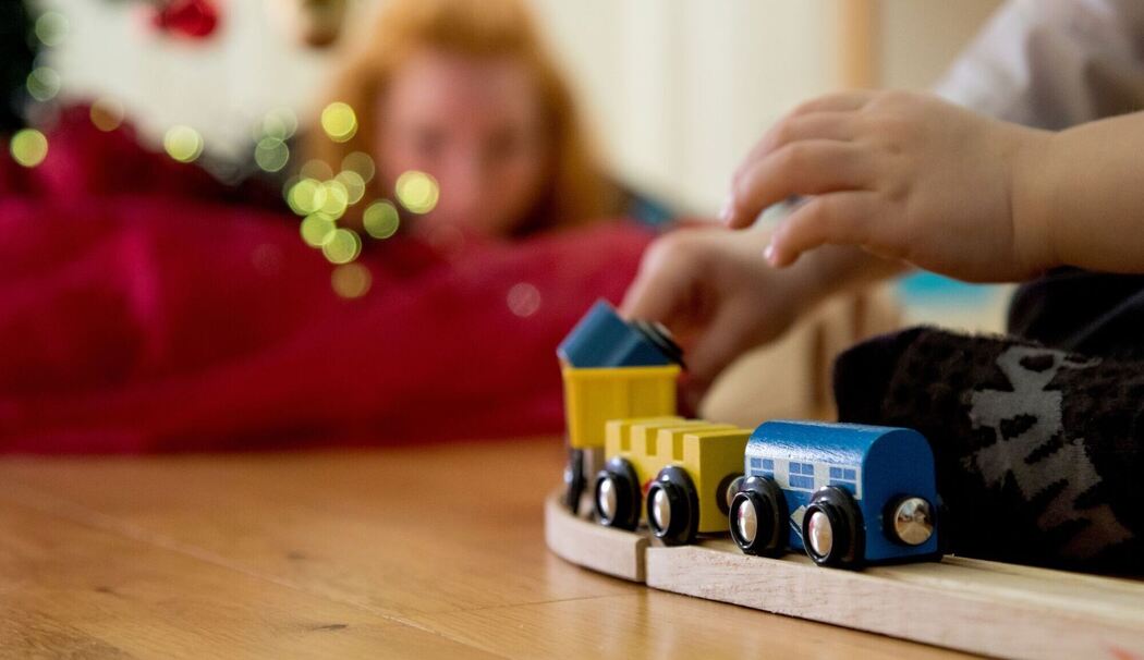 Ein Kind spielt mit einer Holzeisenbahn Ein Kind spielt mit einer Holzeisenbahn