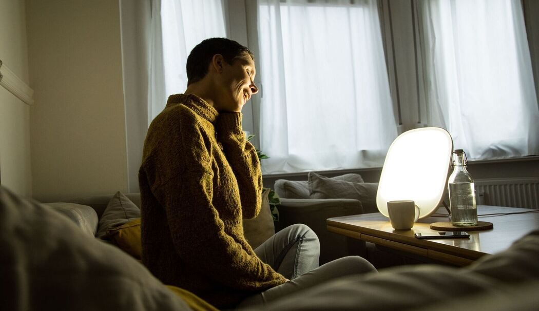 Frau sitzt vor einer Tageslichtlampe Frau sitzt vor einer Tageslichtlampe