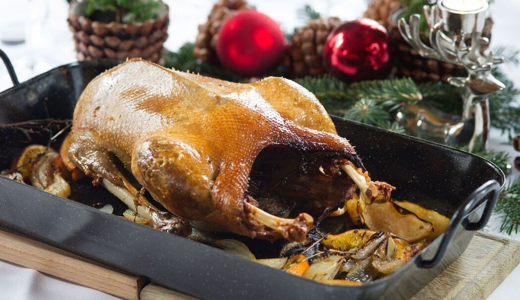 Ein Gänsebraten steht auf einem festlich gedeckten Tisch
