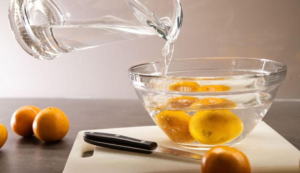 Clementinen werden mit heißem Wasser übergossen