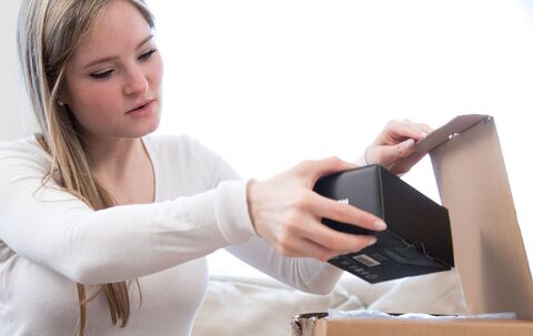 Eine Frau öffnet ein Paket