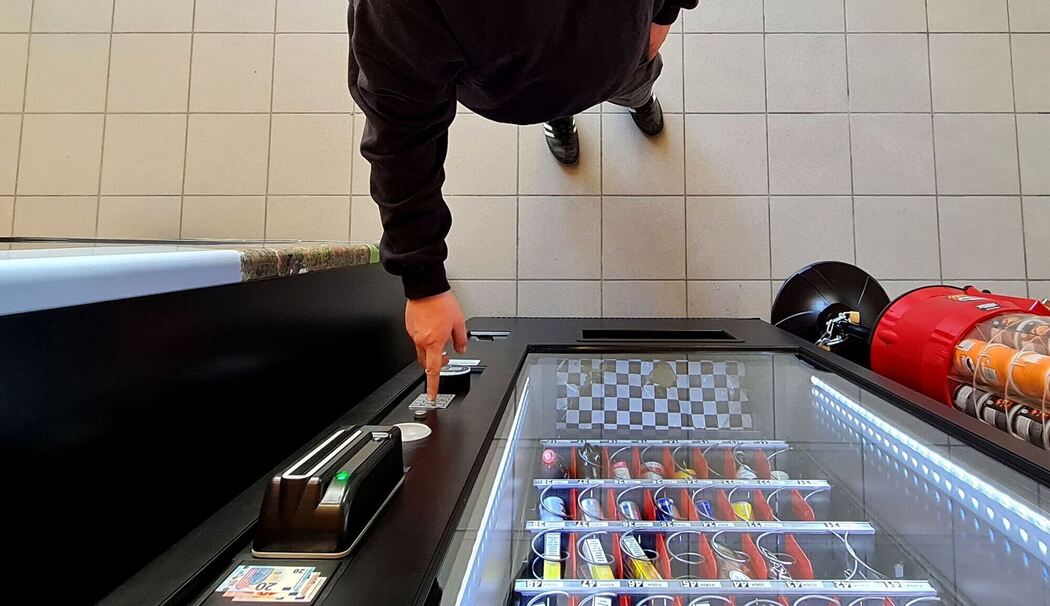 GEin Mann kauft etwas aus dem Automaten GEin Mann kauft etwas aus dem Automaten