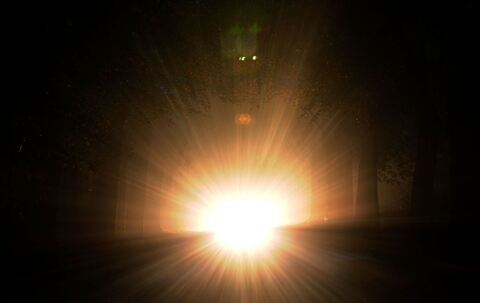 Auto mit Aufblendlicht bei Nacht