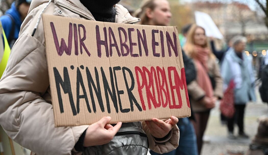 Eine Frau hält ein Schild mit  «Wir haben ein Männerproblem»