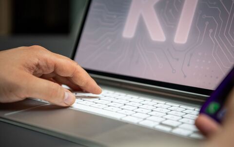 Ein Mann nutzt einen KI-Assistenten auf einem iPad und iPhone