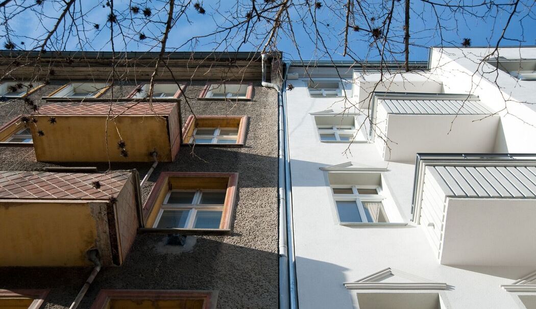 Ein unsaniertes Mehrfamilienhaus neben einem sanierten Haus