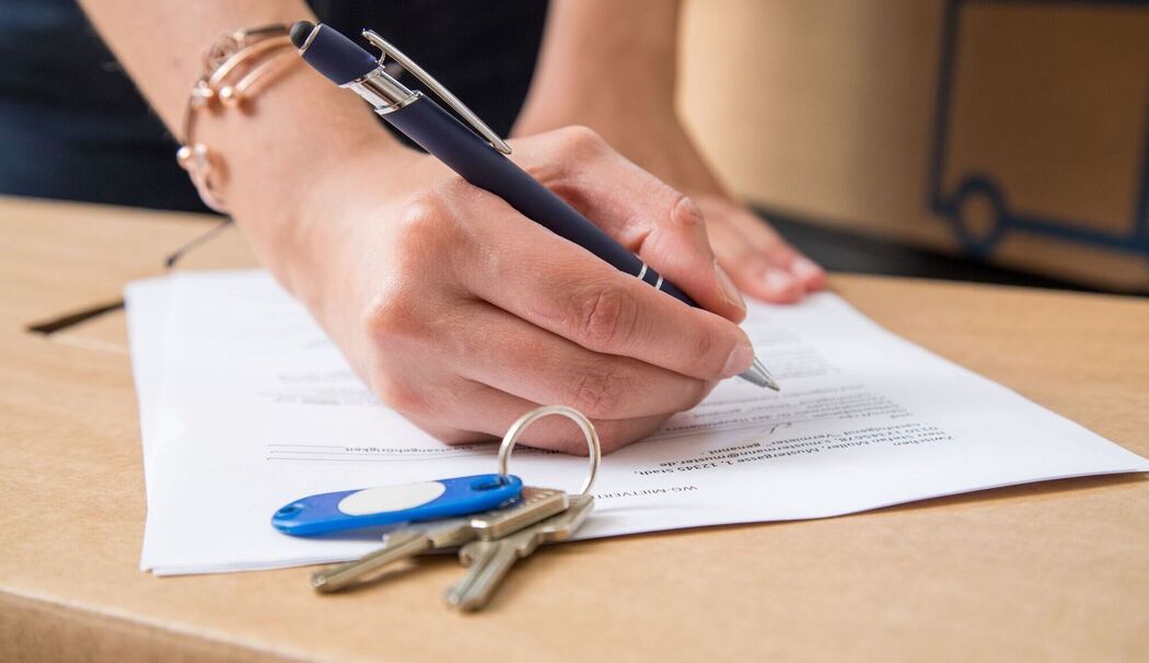 Eine Frau unterschreibt einen Mietvertrag