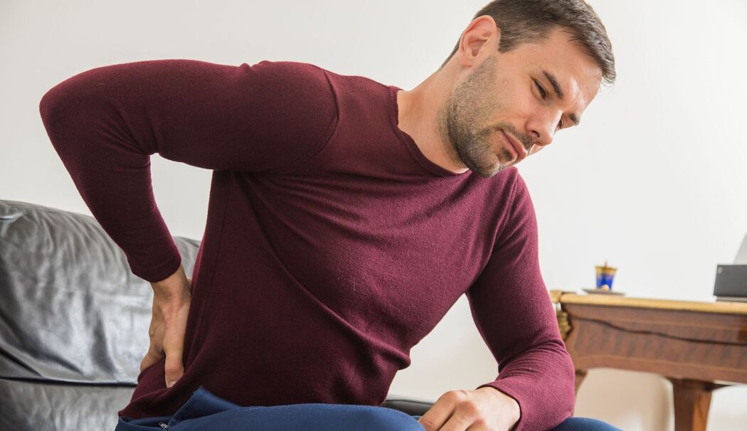 Ein Mann hat Rückenschmerzen Ein Mann hat Rückenschmerzen