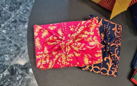 Ein mit Stoffen verpacktes Geschenk liegt auf dem Tisch