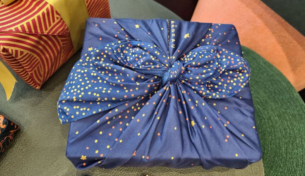 Ein mit Stoffen verpacktes Geschenk liegt auf dem Tisch Ein mit Stoffen verpacktes Geschenk liegt auf dem Tisch