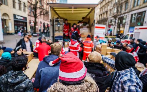 Ehrenamtliche Helfer verteilen Spenden an Bedürftige