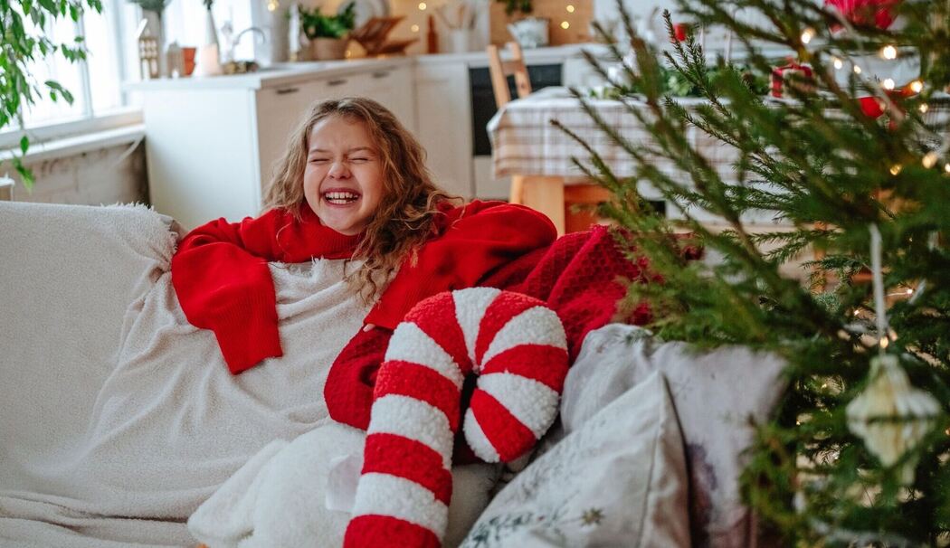 Mädchen lacht voller Vorfreude während der Weihnachtszeit