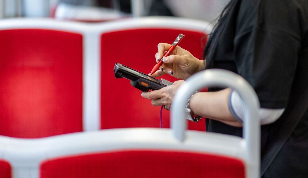 Eine Fahrkartenkontrolleurin kontrolliert einen Fahrgast