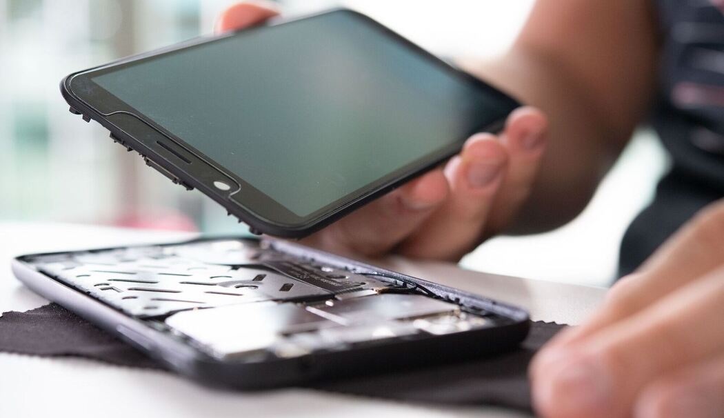 Mann baut ein Smartphone auseinander