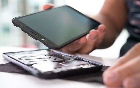 Mann baut ein Smartphone auseinander