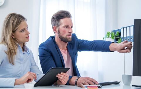 Kollegen blicken auf einen Monitor
