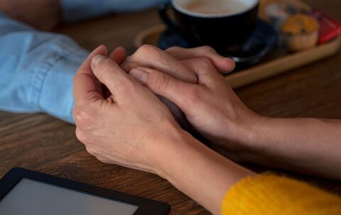 Zwei Personen halten sich an den Händen